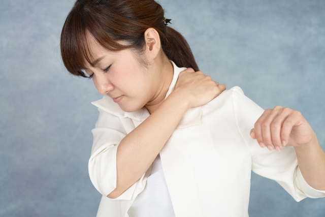 肩の痛みで腕を上げるのが辛くて悩む女性